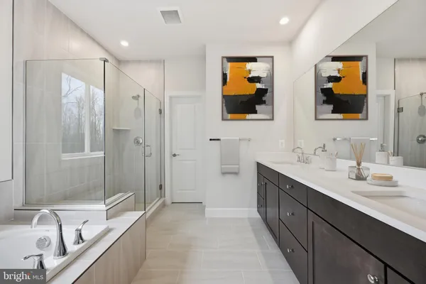 a bathroom with a sink a large mirror and a bathtub