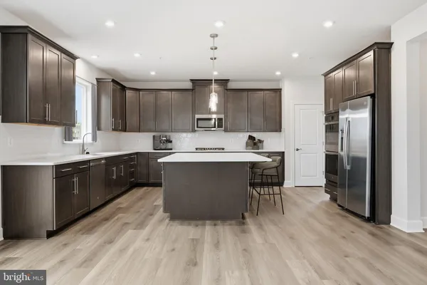 a large kitchen with kitchen island a sink stainless steel appliances and cabinets