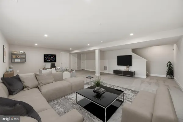 a living room with furniture a flat screen tv and a couch