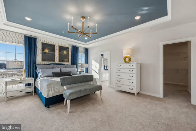 a spacious bedroom with a bed a ceiling fan and a flat tv screen