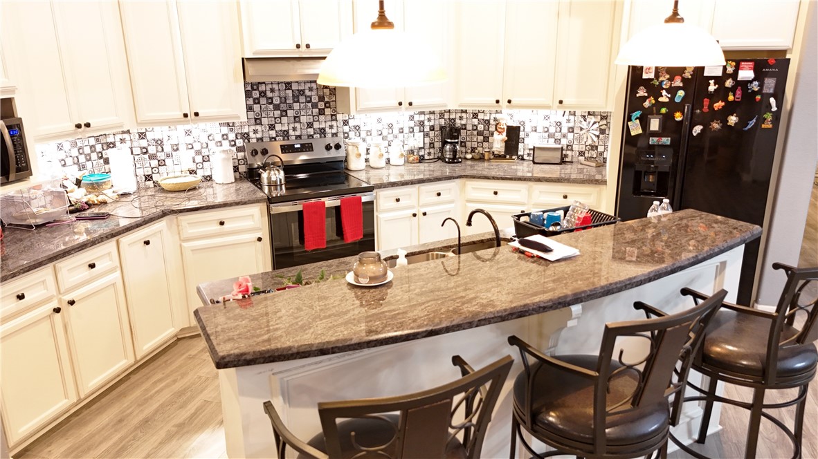 570 County Road 137 Alice, TX 78332 - Photo 13 of 30 a kitchen with a table chairs and cabinets