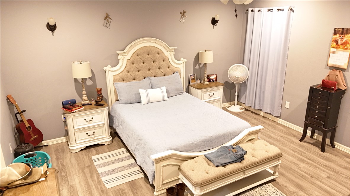 570 County Road 137 Alice, TX 78332 - Photo 16 of 30 a bed room with a bed a dresser and potted plants