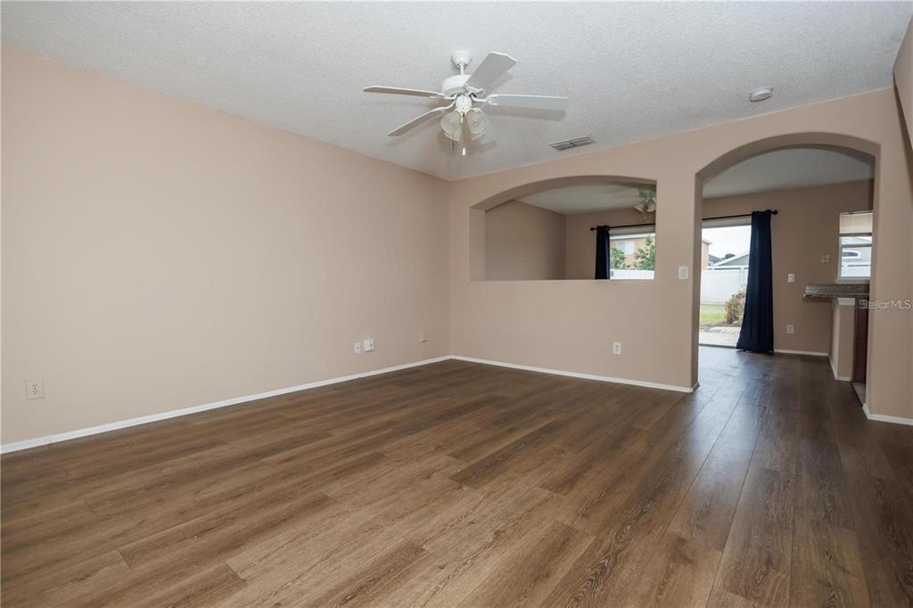 1112 Timberbend Circle Orlando, FL 32824 - Photo 19 of 32 a view of an empty room with wooden floor and a ceiling fan