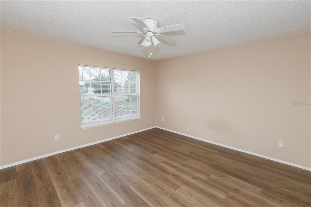 1112 Timberbend Circle Orlando, FL 32824 - Photo 29 of 32 an empty room with wooden floor chandelier fan and windows