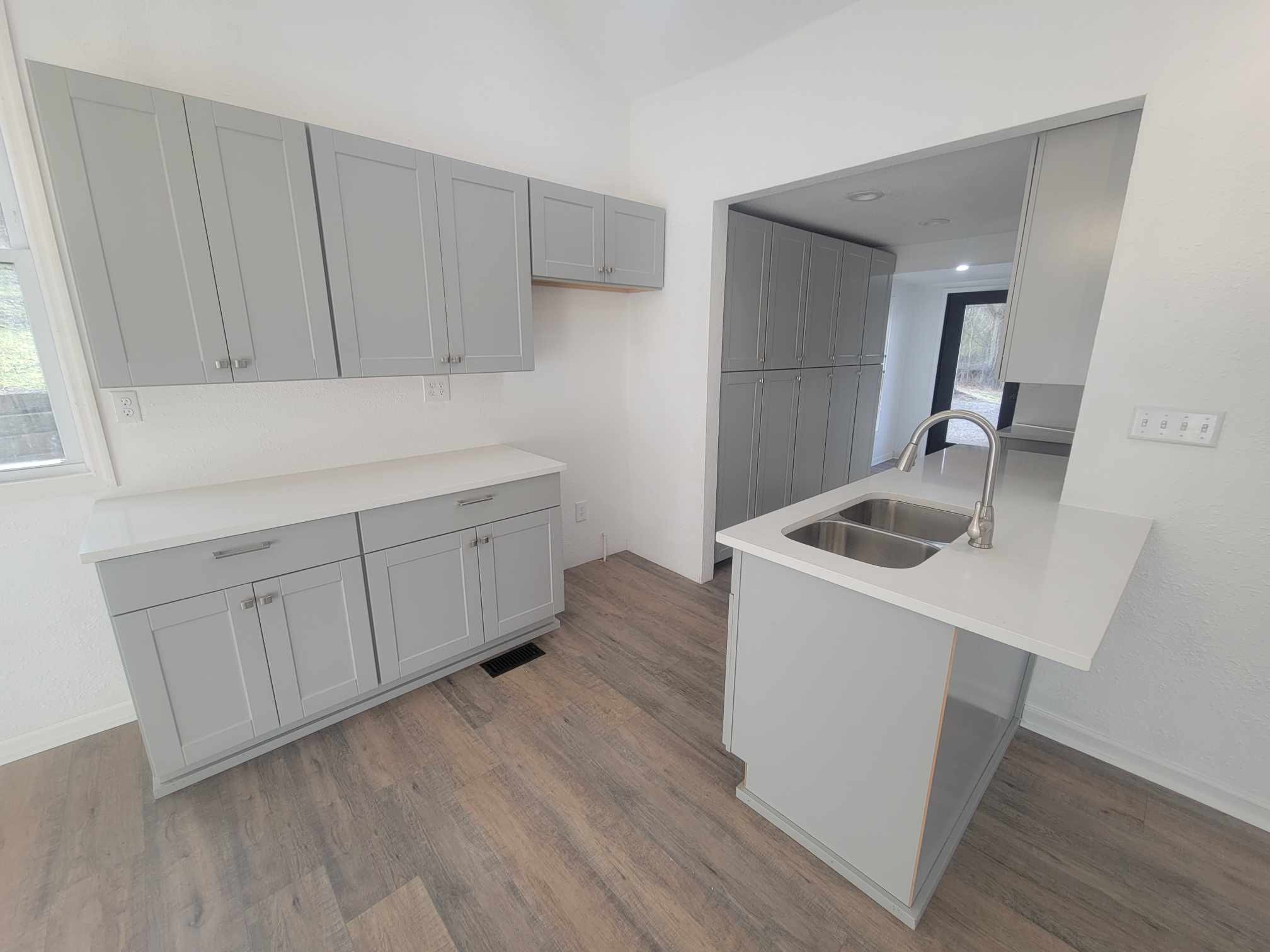 363 Enigma Road Chestnut Mound, TN 38552 - Photo 15 of 60 a kitchen with white cabinets a sink and wooden floor