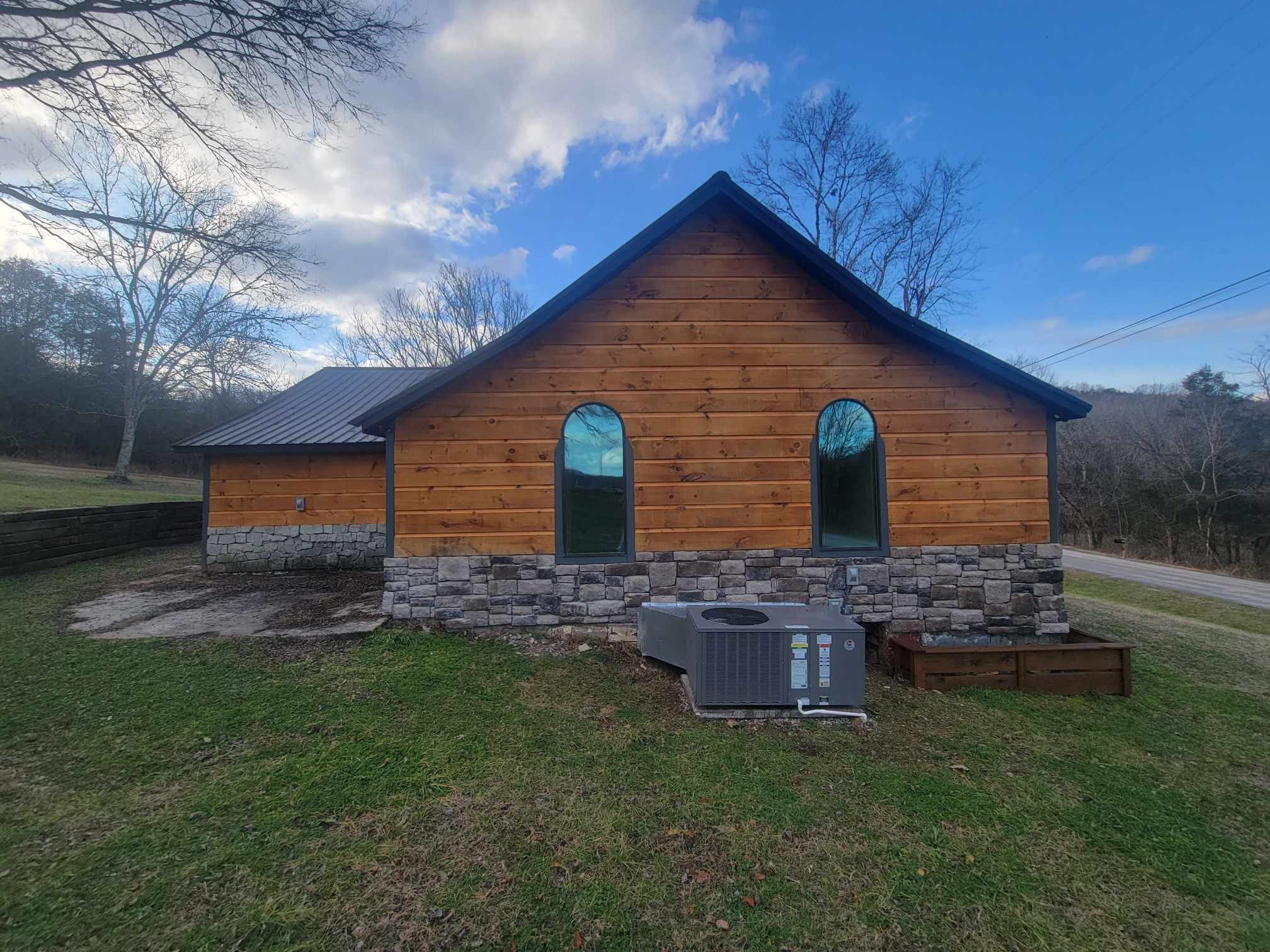 363 Enigma Road Chestnut Mound, TN 38552 - Photo 33 of 60 a stone house with a small yard and wooden fence