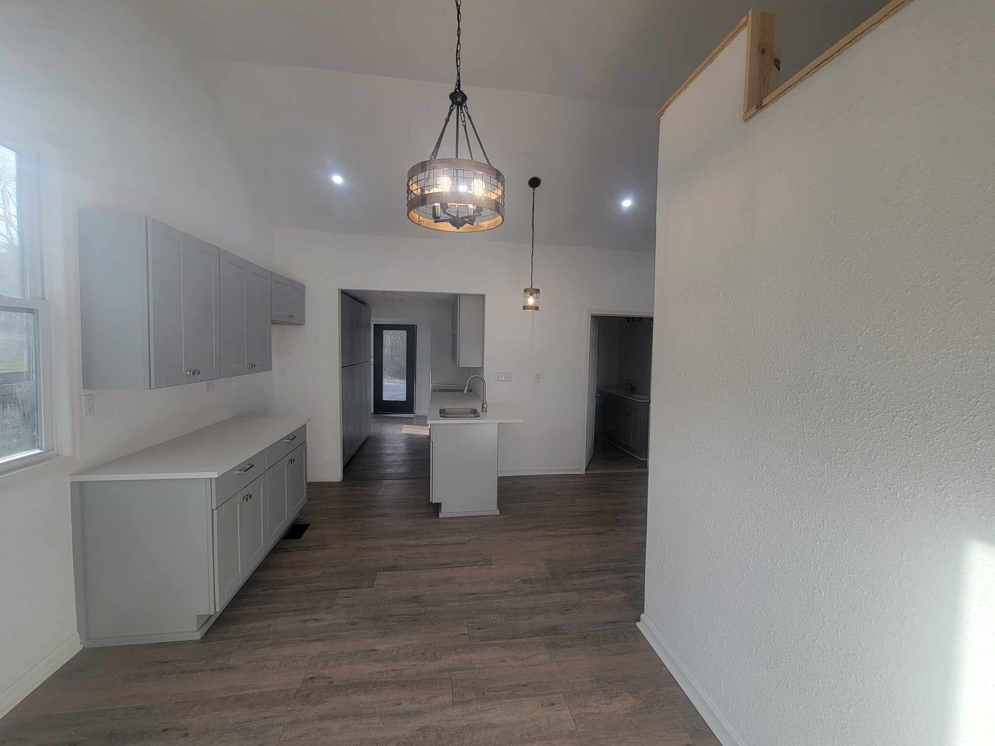 363 Enigma Road Chestnut Mound, TN 38552 - Photo 47 of 60 an empty room with wooden floor and kitchen view