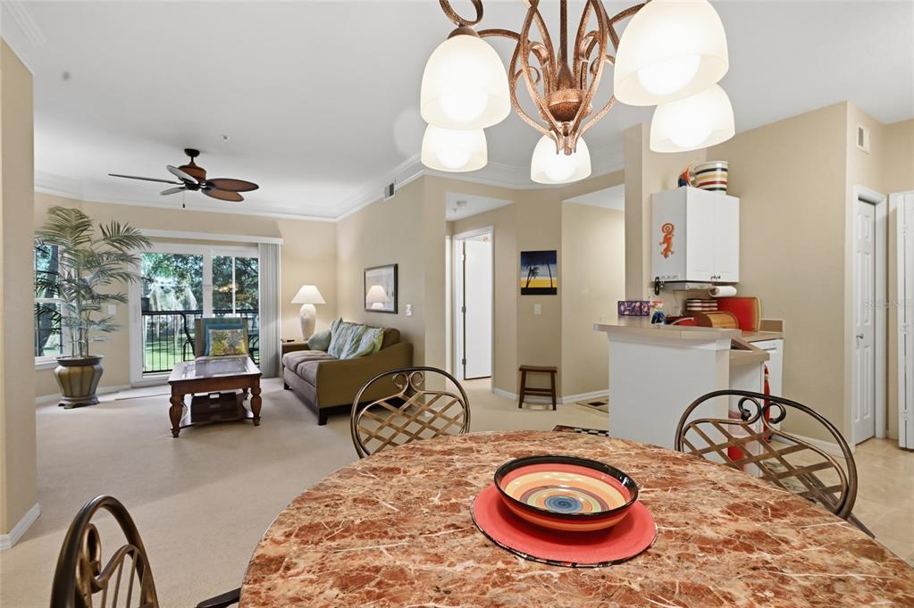 5122 Northridge Road, Unit 210 Sarasota, FL 34238 - Photo 12 of 36 a living room with furniture a chandelier and a large window
