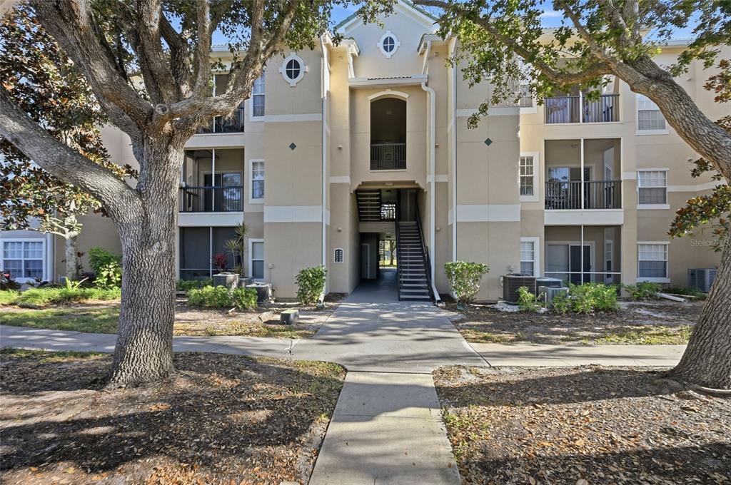 5122 Northridge Road, Unit 210 Sarasota, FL 34238 - Photo 2 of 36 a front view of a house with garden and trees