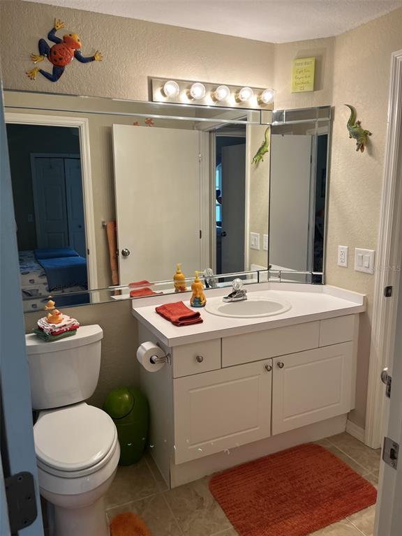 5122 Northridge Road, Unit 210 Sarasota, FL 34238 - Photo 21 of 36 a bathroom with a toilet sink and mirror