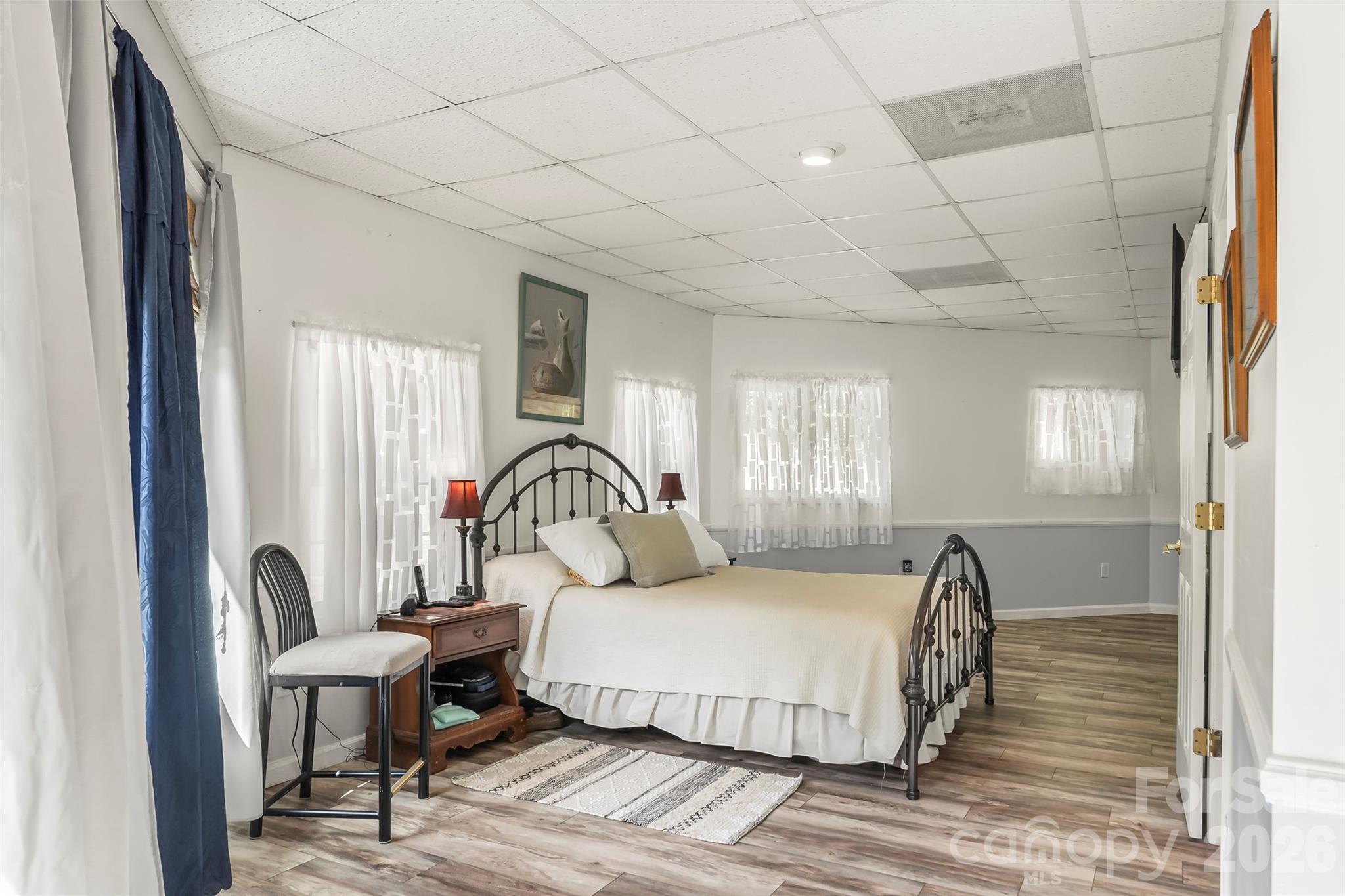 214 Locust Cove Road Marion, NC 28752 - Photo 30 of 47 a bedroom with a large bed and a chandelier