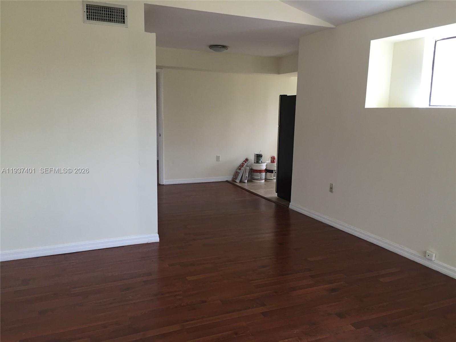 10441 Southwest 156th Court, Unit 421 Miami, FL 33196 - Photo 8 of 36 an empty room with wooden floor and windows