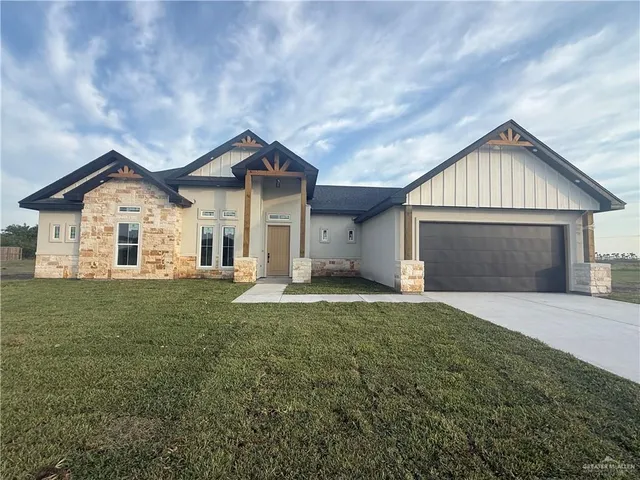 a front view of a house with a garden and yard
