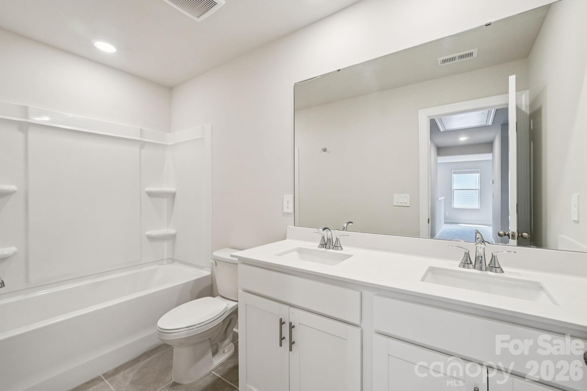 2452 Chartwell Street Stanley, NC 28164 - Photo 12 of 15 a bathroom with a double vanity sink toilet tub and shower