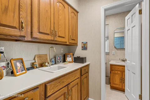 a kitchen with stainless steel appliances granite countertop a sink a stove and a wooden cabinets