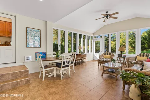 a dining room with furniture a large window and a rug