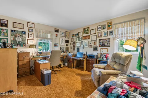 a living room with furniture a bookshelf and a window