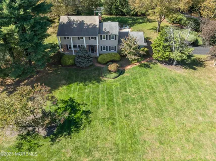 an aerial view of a house with a yard and large trees