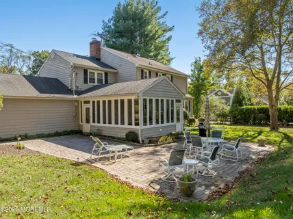 a view of a chair and table in backyard of the house