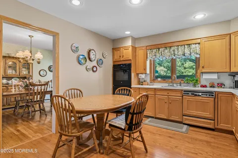 a kitchen with granite countertop stainless steel appliances a dining table and chairs