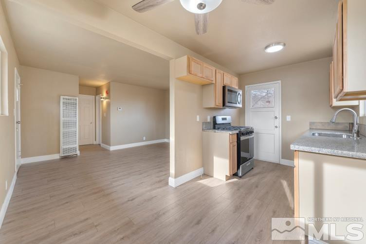 565 Colorado River Boulevard Reno, NV 89502 - Photo 1 of 25 a kitchen with stainless steel appliances granite countertop a refrigerator a sink dishwasher and a stove with wooden floor