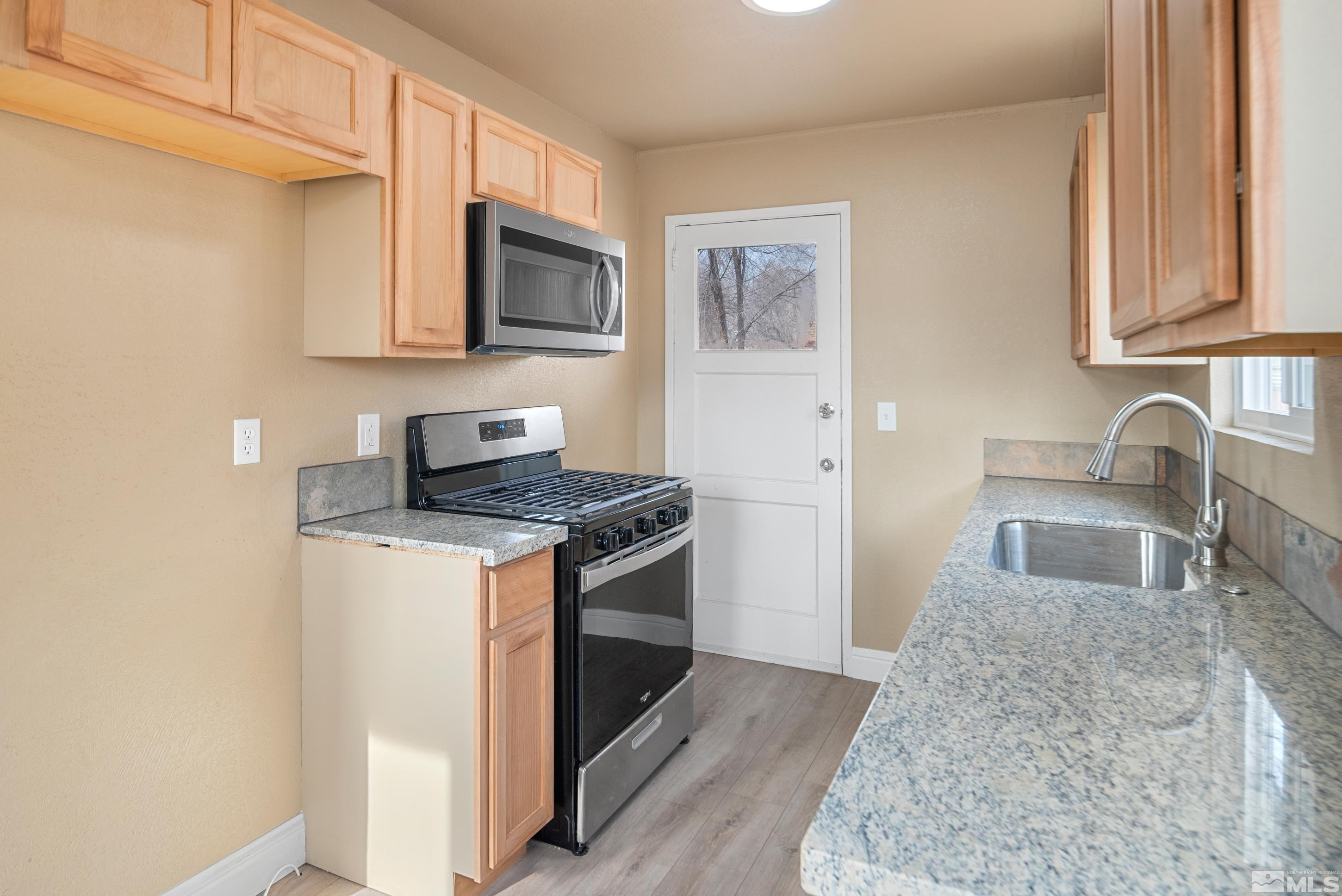 565 Colorado River Boulevard Reno, NV 89502 - Photo 6 of 25 a kitchen with stainless steel appliances granite countertop a stove microwave and sink