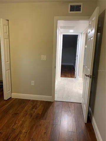 a view of a hallway with wooden floor and a hallway