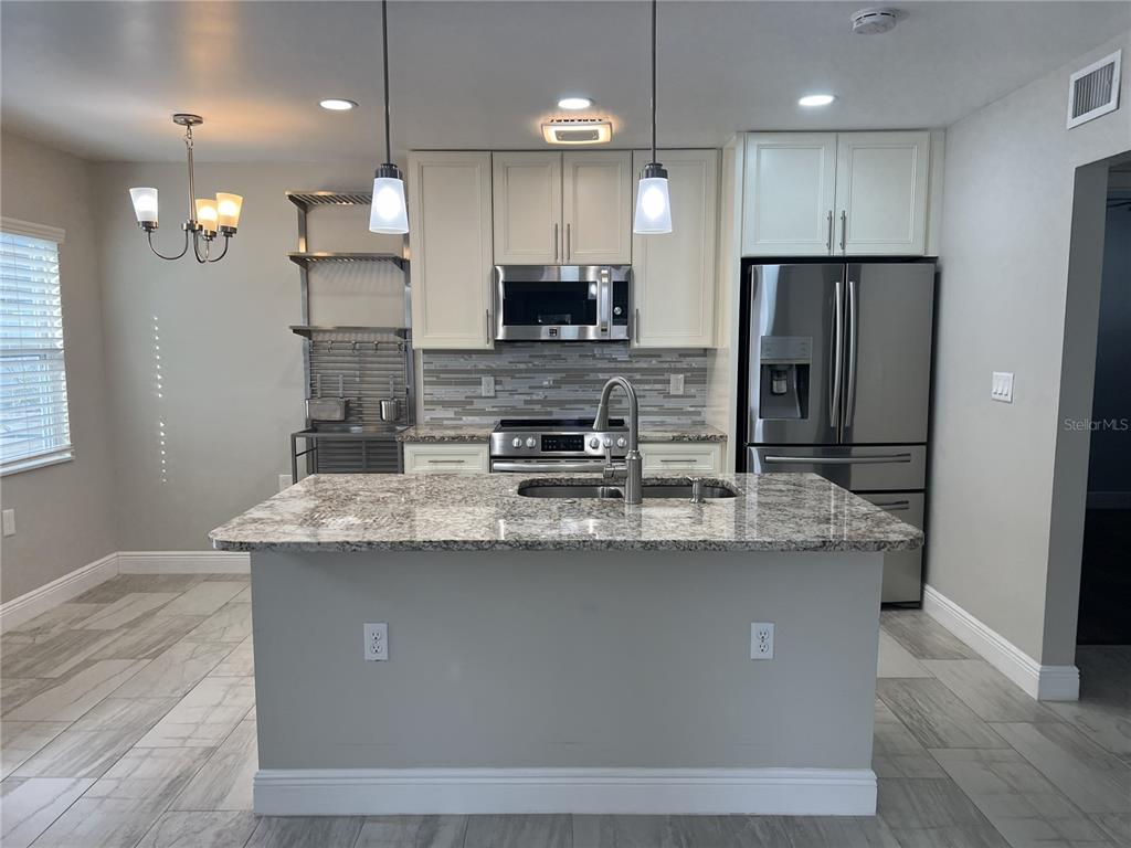 1742 8th Street Sarasota, FL 34236 - Photo 4 of 19 a kitchen with kitchen island stainless steel appliances a sink and a refrigerator