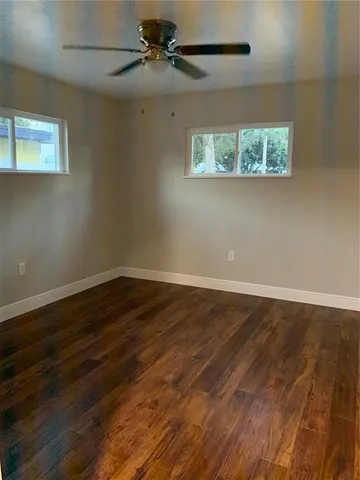 a view of a big room with wooden floor closet and windows