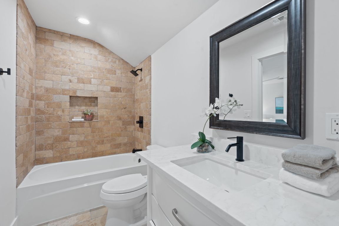 1325 Likeness Road Spicewood, TX 78669 - Photo 23 of 38 Bathroom featuring bathtub / shower combination, vanity, vaulted ceiling, and recessed lighting