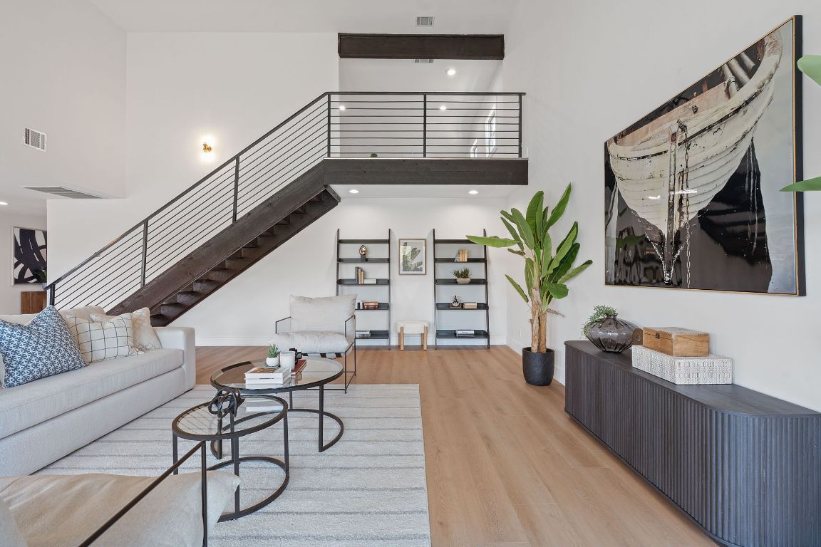1325 Likeness Road Spicewood, TX 78669 - Photo 3 of 38 Living area with wood finished floors, a high ceiling, and stairway