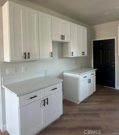 a kitchen with white cabinets and white appliances