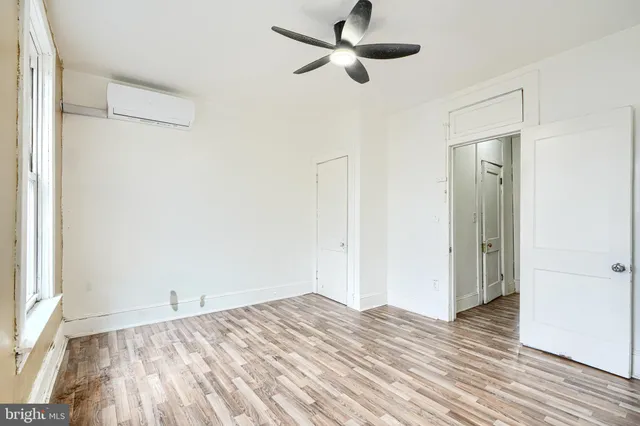 a view of a room with wooden floor and ceiling fan