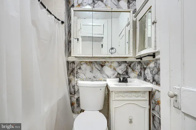 a bathroom with a toilet sink and mirror