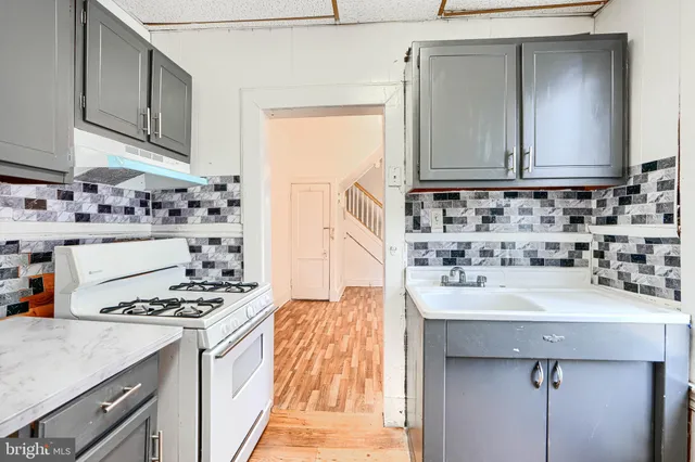 a kitchen with sink a stove and cabinets