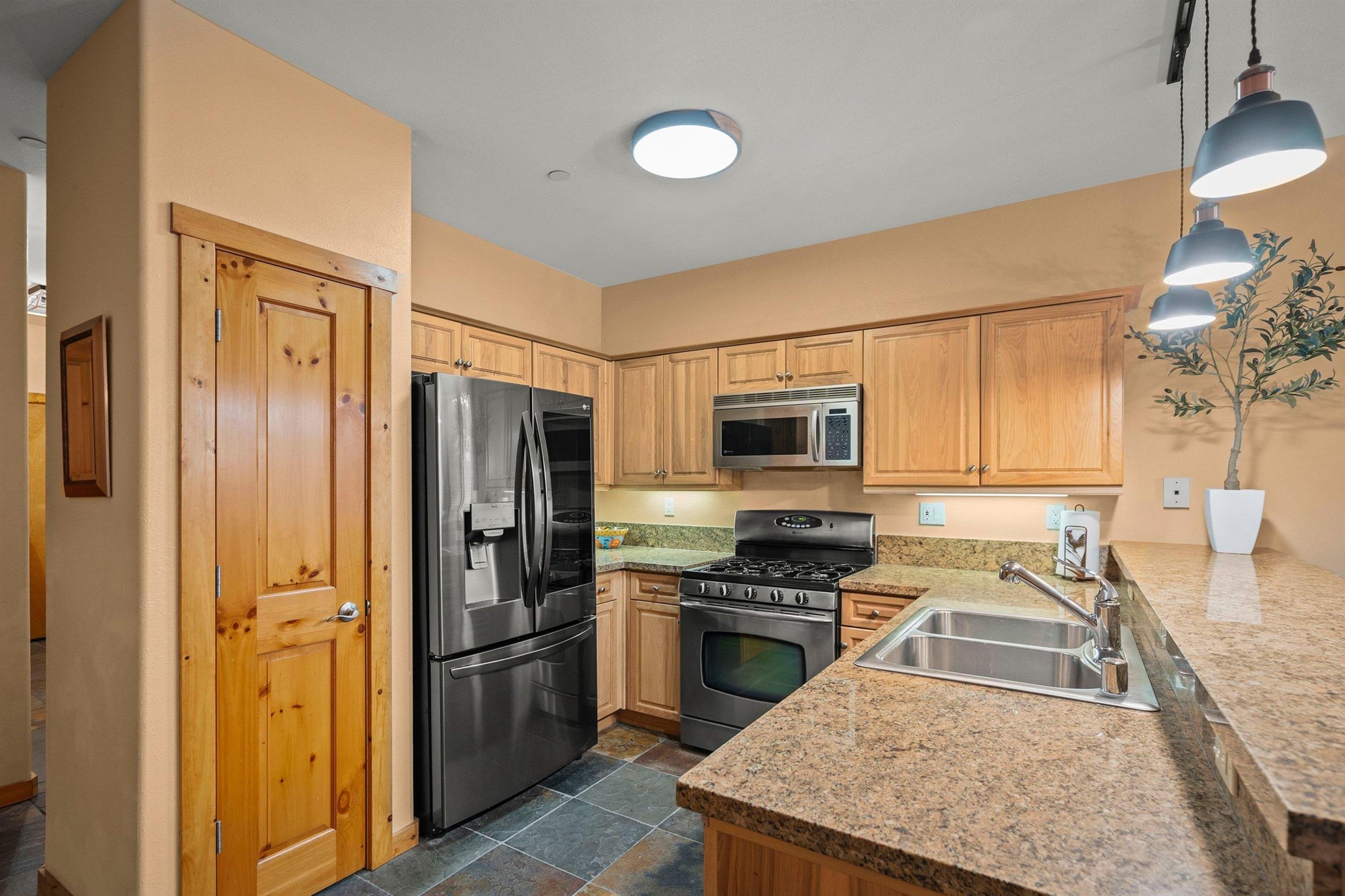 11420 Dolomite Way, Unit 1 Truckee, CA 96161 - Photo 9 of 28 a kitchen with stainless steel appliances granite countertop a refrigerator stove and sink