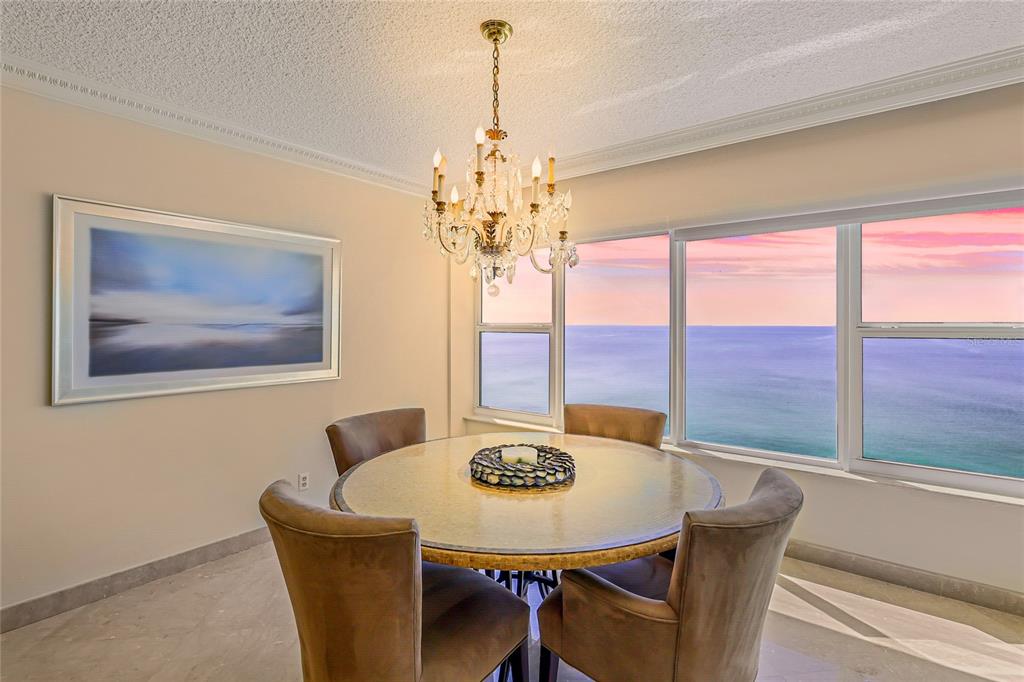 603 Longboat Club Road, Unit 1103N Longboat Key, FL 34228 - Photo 6 of 37 a view of a dining room with furniture a chandelier and large windows