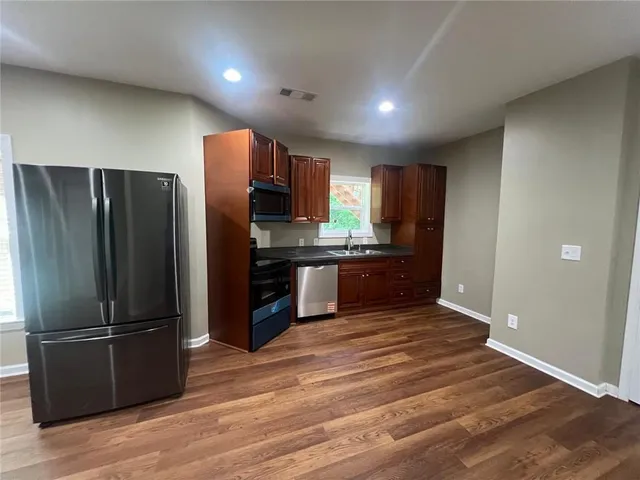a kitchen with stainless steel appliances wooden cabinets and microwave