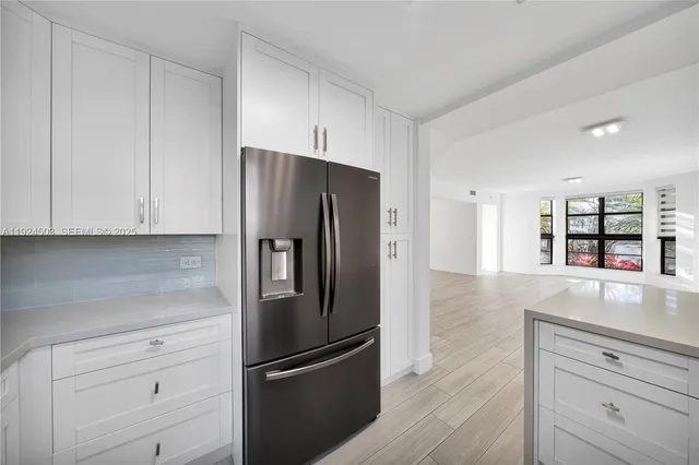 a kitchen with granite countertop white cabinets and stainless steel appliances