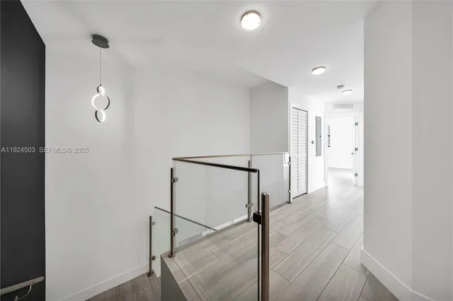 a view of a hallway with wooden floor