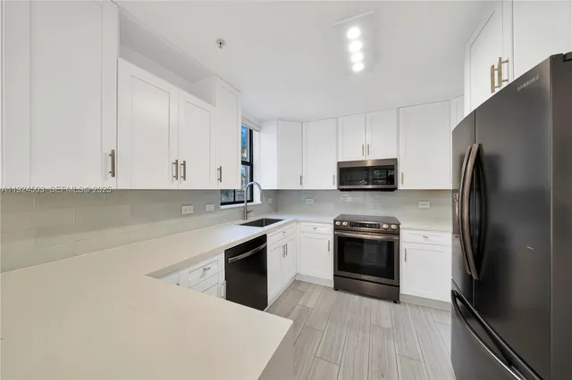 a kitchen with granite countertop white cabinets and stainless steel appliances
