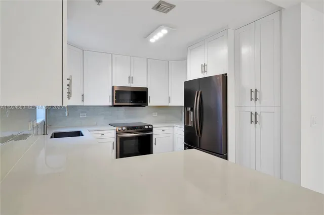 a kitchen with stainless steel appliances granite countertop a refrigerator stove and microwave