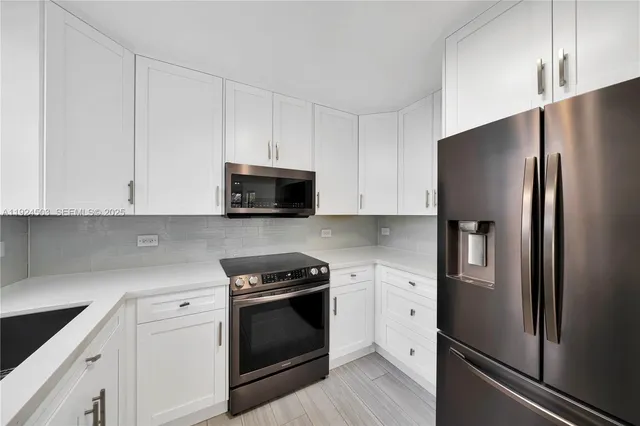 a kitchen with white cabinets and stainless steel appliances