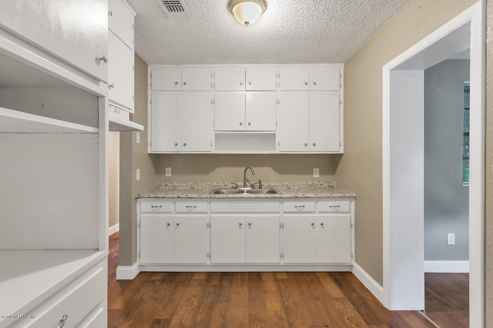 6718 Cavalier Road Jacksonville, FL 32208 - Photo 4 of 15 a view of cabinets and wooden floor