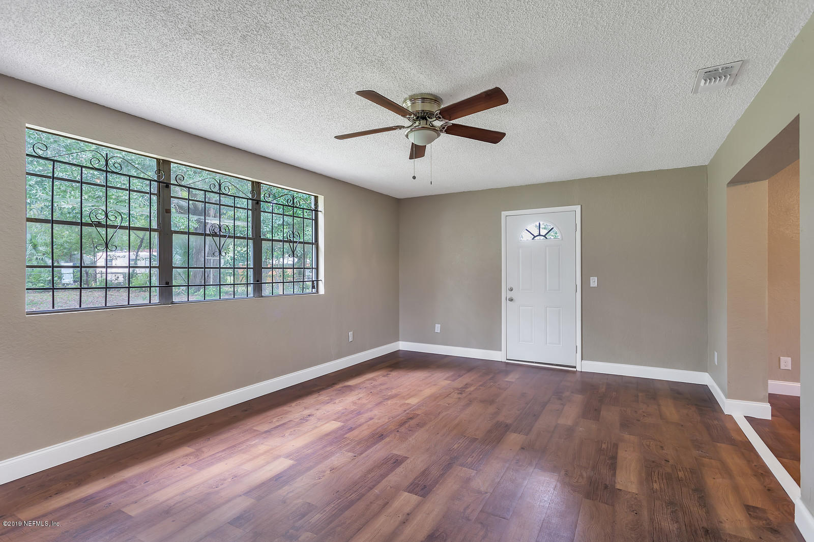 6718 Cavalier Road Jacksonville, FL 32208 - Photo 8 of 15 a view of an empty room with wooden floor and a window