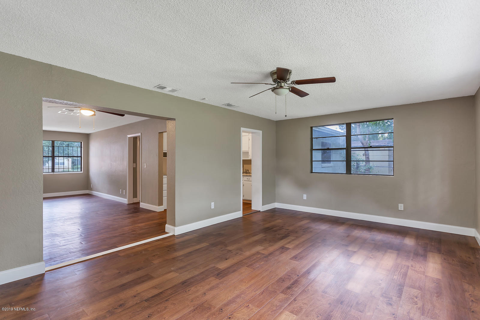 6718 Cavalier Road Jacksonville, FL 32208 - Photo 9 of 15 a view of an empty room with a window and wooden floor
