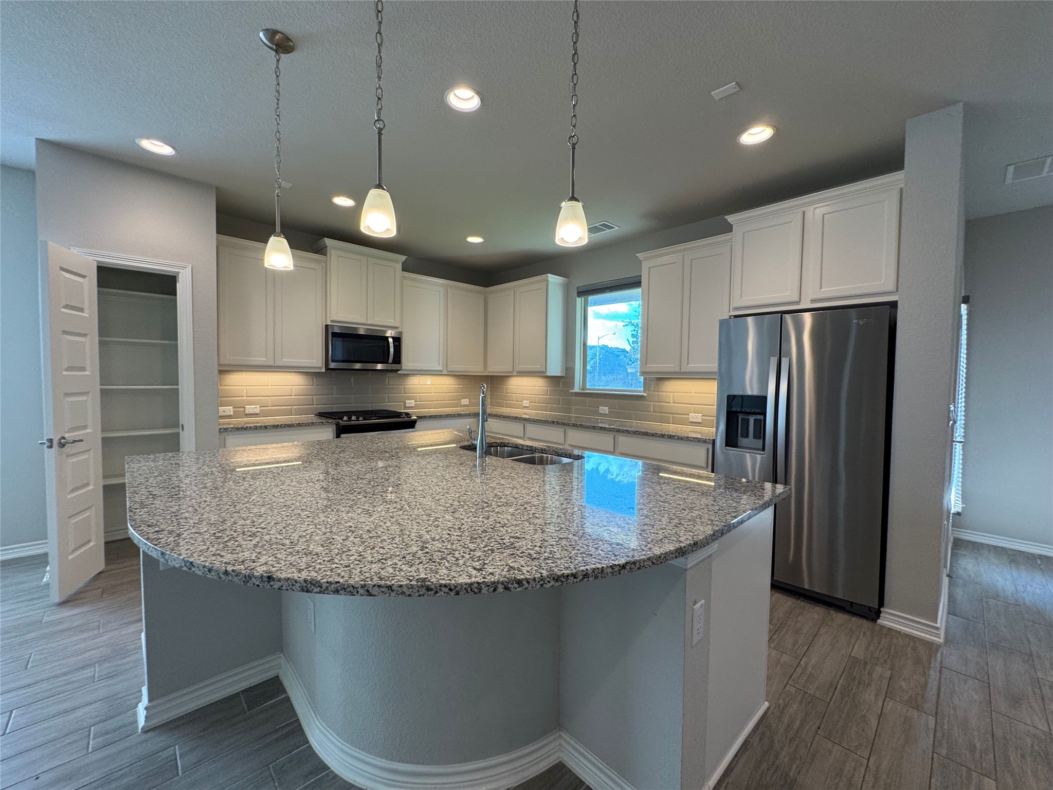 14100 McCoy Loop, Unit 1 Austin, TX 78717 - Photo 7 of 39 A spacious kitchen features a generously sized island, perfect for culinary adventures and casual dining.