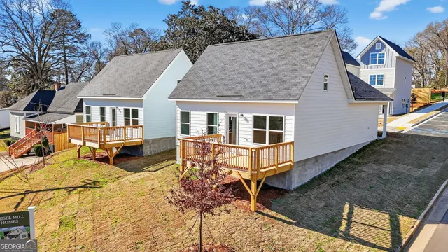 a view of a house with wooden deck and furniture