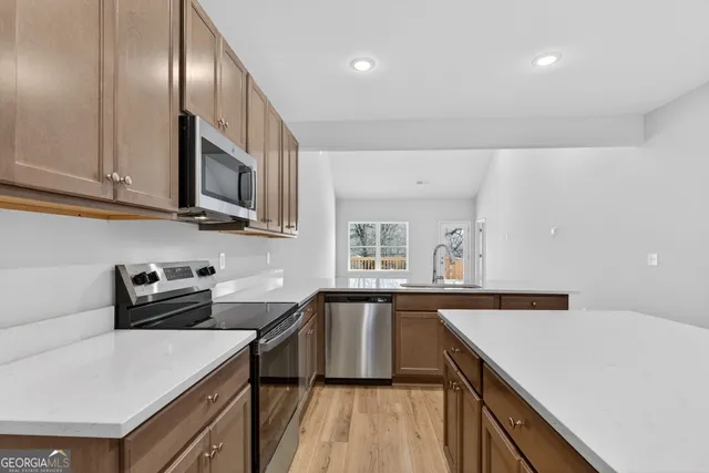 a kitchen that has a sink a stove and cabinets