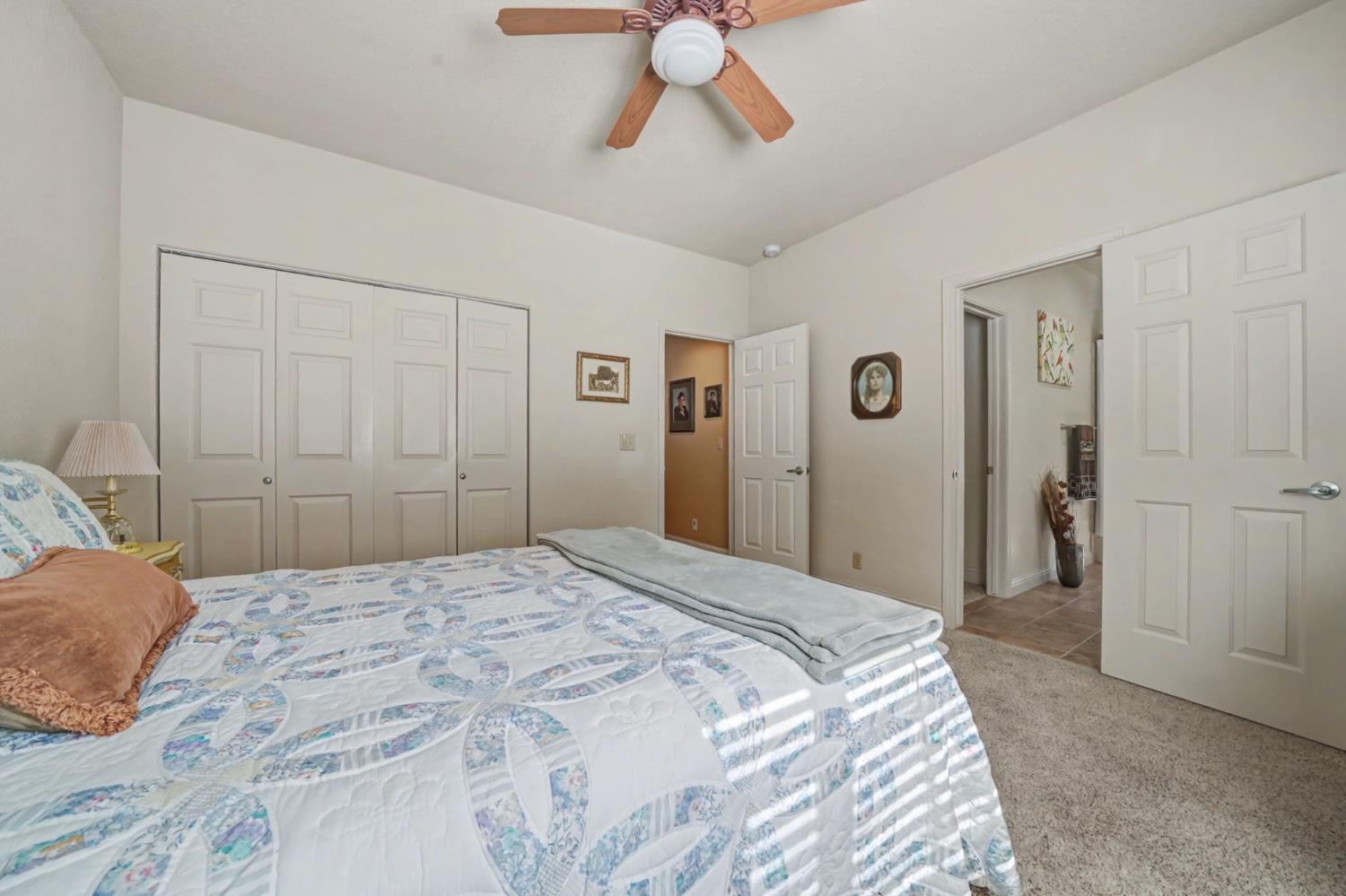 16111 Pioneer Creek Road Pioneer, CA 95666 - Photo 32 of 59 a bedroom with a large bed and a chandelier